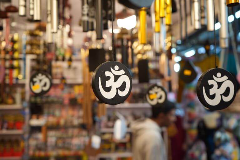Decorative Om symbols hanging in a busy shop, creating a spiritual atmosphere.